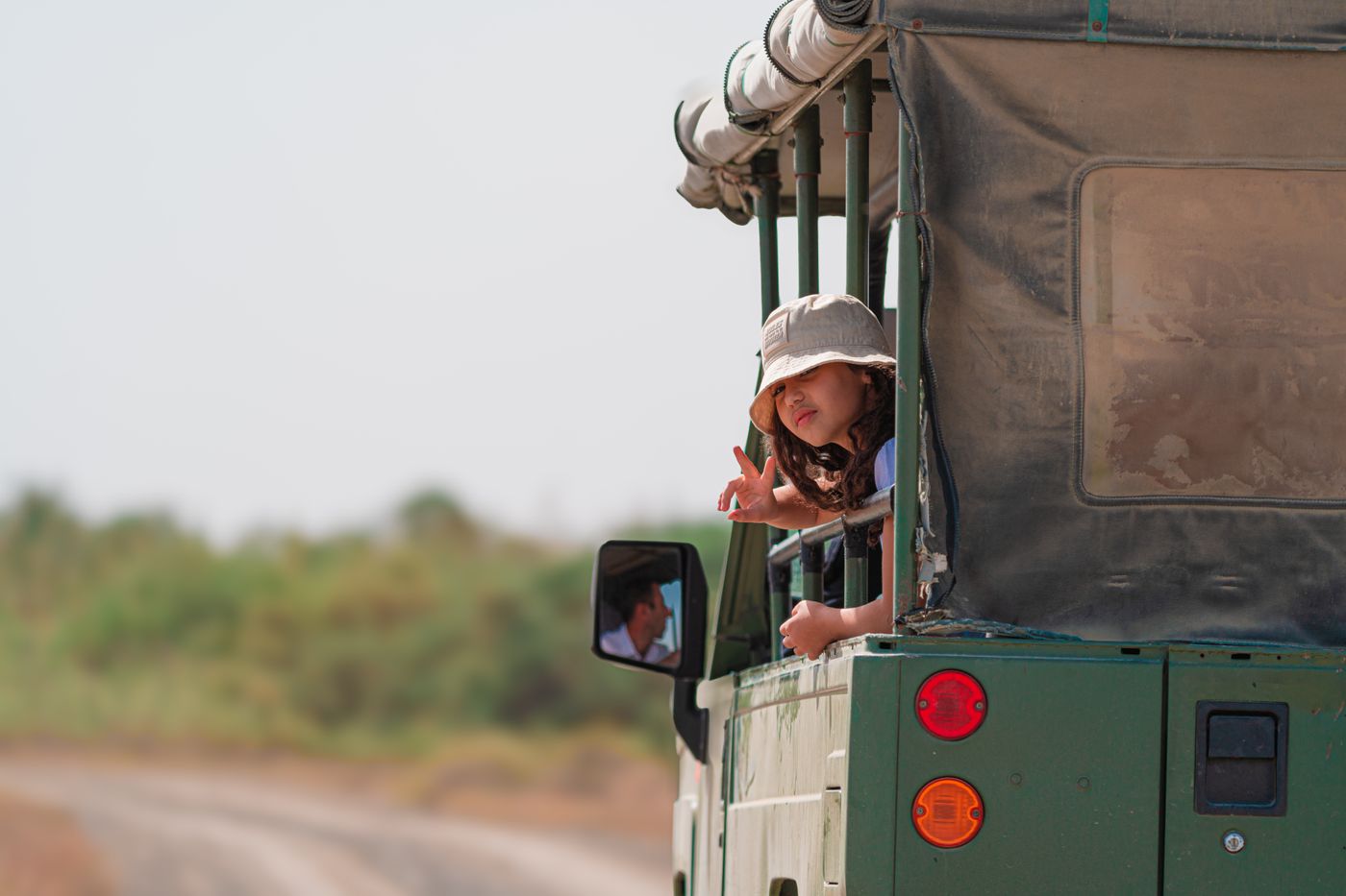 A child enjoying a wildlife safari from an open-top jeep